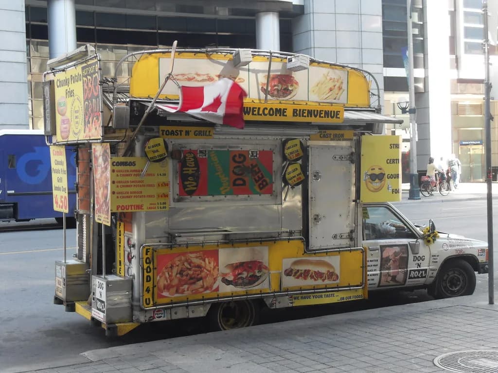 Yellow food truck serving customers on a city street